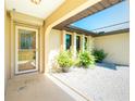 Inviting front porch with decorative plants, a secured front door, and white gravel at 25422 Aysen Dr, Punta Gorda, FL 33983