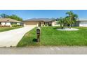 Landscaped single-story home with green grass and a gray roof, adding to its curb appeal at 25422 Aysen Dr, Punta Gorda, FL 33983