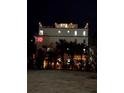 Nighttime view of multi-story condo building with rooftop deck and tropical landscaping at 322 Beach Rd, Sarasota, FL 34242
