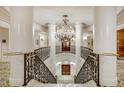 A stunning ornate staircase and wrought iron railing beneath a dazzling chandelier in a luxury building at 35 Watergate Dr # 1402, Sarasota, FL 34236