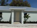 Inviting home entrance with a modern covered entry, complemented by fresh landscaping at 3525 Mcintosh Rd, Sarasota, FL 34232