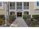 Inviting entrance to the Banana Wind condos with lush landscaping and charming brick pathway at 384 Aruba Cir # 103, Bradenton, FL 34209