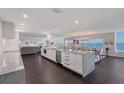 Gourmet kitchen featuring sleek white cabinets, granite countertops, stainless steel appliances, and gorgeous water views at 400 Golden Gate Pt # 51 & 52, Sarasota, FL 34236