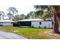 Well-maintained home with lush lawn, mature trees, and a private driveway for parking at 411 S Oxford Dr # 411, Nokomis, FL 34275