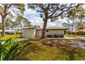 Lovely home featuring an attached garage, mature trees, and a patio area with comfortable seating at 411 S Oxford Dr # 411, Nokomis, FL 34275
