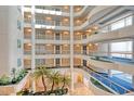 Multi story view of the building's interior featuring plants, carpeted walkways, and an open-air layout at 455 Longboat Club Rd # 407, Longboat Key, FL 34228