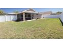 Spacious backyard with a screened-in lanai and a white privacy fence at 4636 72Nd E Ct, Bradenton, FL 34203