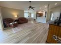 Open-concept living area with wood floors, ceiling fan, and view of the dining area and kitchen at 4636 72Nd E Ct, Bradenton, FL 34203
