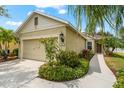 Charming single-story home featuring a landscaped front yard with flowers and an attached garage at 4954 Newport News Cir, Lakewood Ranch, FL 34211