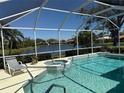 Relaxing screened-in pool and spa offer a peaceful retreat with serene lake views at 5087 Timber Chase Way, Sarasota, FL 34238