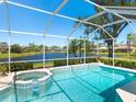 A screened-in pool and jacuzzi offer a serene view of the adjacent pond at 5087 Timber Chase Way, Sarasota, FL 34238