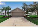 Charming single-story home featuring a spacious two-car garage, well-maintained lawn, and mature landscaping at 5511 71St E St, Palmetto, FL 34221