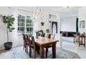 Bright dining room featuring a large window, modern chandelier, wood table, and view to the front door at 5806 43Rd E Ct, Bradenton, FL 34203