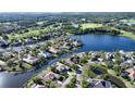 Aerial view of the home in a lake community surrounded by lush greenery and a golf course at 7340 Barclay Ct, University Park, FL 34201