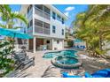 Beautiful backyard featuring a pool, spa, bar, lounge chairs, lush greenery, and an outdoor living area at 785 Jacaranda Rd, Anna Maria, FL 34216