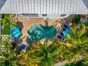 Aerial view of a kidney-shaped pool with beautiful stone surround, spa, and lounge chairs at 785 Jacaranda Rd, Anna Maria, FL 34216
