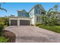 Inviting two-story home featuring a brick driveway and a two-car garage, complemented by lush landscaping at 8227 37Th Avenue W Cir, Bradenton, FL 34209