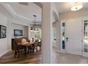 Welcoming foyer with wood floors flowing into dining room with a large dining table and front door at 8227 37Th Avenue W Cir, Bradenton, FL 34209