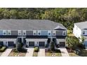 This townhome features a gray roof, gray and blue siding, and a well-manicured front yard at 8521 Canyon Creek Trl, Parrish, FL 34219