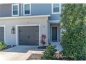 The townhome has light gray siding, a dark gray garage door, and is nicely landscaped at 8521 Canyon Creek Trl, Parrish, FL 34219