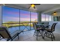 Screened lanai showcases water views with a ceiling fan, tiled floors, and a dining set for outdoor enjoyment at 9203 Griggs Rd # A302, Englewood, FL 34224