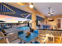 Covered patio featuring blue and white awnings, ceiling fans, an outdoor kitchen, and a beautiful water view at 1009 3Rd E St, Palmetto, FL 34221