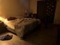 Interior view of a dark main bedroom with a bed, nightstand, and minimal lighting at 10443 Keystone St, Spring Hill, FL 34608