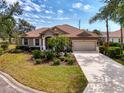 Beautiful single-story home boasting mature landscaping, a tile roof, a two-car garage, and a well-maintained lawn at 107 Wayforest Dr, Venice, FL 34292