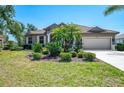 Charming single-story home featuring mature landscaping, a tile roof, and a spacious driveway leading to an attached two-car garage at 107 Wayforest Dr, Venice, FL 34292
