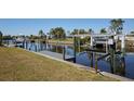 Scenic waterfront view with a private dock, boat lift, and canal access for boating and enjoying the water at 125 Palmetto Ne Cir, Port Charlotte, FL 33952
