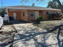 Cozy home featuring a covered carport, orange siding, and a well-maintained front yard at 1804 Bayshore Gardens Pkwy, Bradenton, FL 34207