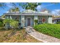 Inviting home exterior featuring a brick walkway, lush greenery, and a quaint covered porch area at 2021 Central Ave, Sarasota, FL 34234