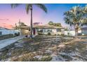 Cozy single-story home features a charming carport, attractive white fencing and mature landscaping with two palm trees at 2207 Holyoke Ave, Bradenton, FL 34207