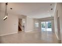 Spacious open-concept living area with neutral tile flooring, recessed lighting, and sliding glass doors at 271 Petrel Trl, Bradenton, FL 34212