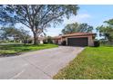 Exterior of a home with a well-maintained lawn, long driveway, mature trees, and a two-car garage at 314 Signorelli Dr, Nokomis, FL 34275