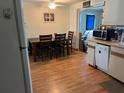 Inviting kitchen and dining space with laminate wood flooring, ceiling fan, and white appliances at 3525 Emory Dr, Holiday, FL 34691