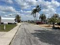 Picturesque neighborhood street with palm trees and well-kept homes under a sunny sky at 3525 Emory Dr, Holiday, FL 34691