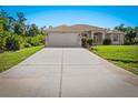 A well-maintained home featuring a spacious driveway, landscaped yard, and a two-car garage at 3528 Monday Ter, North Port, FL 34286