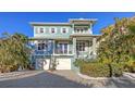 Charming blue two-story home with a brick driveway and white trim at 4941 Commonwealth Dr, Sarasota, FL 34242