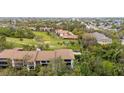 Aerial view showcasing the condo complex set against a backdrop of golf course and lush trees at 6002 Oak Creek Ln # 1925, Bradenton, FL 34210