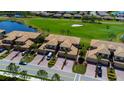 An aerial view of elegant townhomes, showcasing manicured lawns, serene ponds, and the adjacent golf course at 6708 Grand Estuary Trl # 104, Bradenton, FL 34212