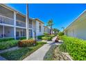 Charming two-story condo featuring beautifully maintained walkway and tropical foliage, ideal for peaceful Florida living at 6912 Drewrys Blf # 608, Bradenton, FL 34203