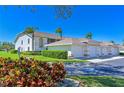 View of complex garages with meticulously kept lawns, vibrant shrubbery, and accessible parking, a perfect residential community at 6912 Drewrys Blf # 608, Bradenton, FL 34203