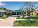 Beautiful home featuring a quaint front porch, well-manicured lawn, and a lovely brick driveway at 710 Fox St, Longboat Key, FL 34228