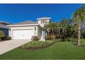 Inviting home exterior featuring lush landscaping, manicured lawn, and a two-car garage at 7742 Ridgelake Cir, Bradenton, FL 34203