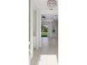 Bright foyer with neutral tile flooring, elegant chandelier, and view to the outdoor patio at 7742 Ridgelake Cir, Bradenton, FL 34203
