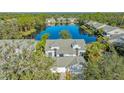 Aerial view showcasing a lakefront home with mature trees and lush landscaping at 7742 Whitebridge Gln, University Park, FL 34201