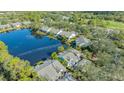 Aerial view of homes bordering a tranquil lake in a lush, green community at 7742 Whitebridge Gln, University Park, FL 34201