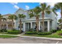 Inviting two-story home with manicured landscaping, swaying palm trees, and a charming front porch at 12130 Seabrook Ave, Bradenton, FL 34211