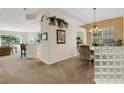 Open-concept dining area with elegant chandelier, carpet flooring, and architectural details at 1311 Triano Cir # 1311, Venice, FL 34292
